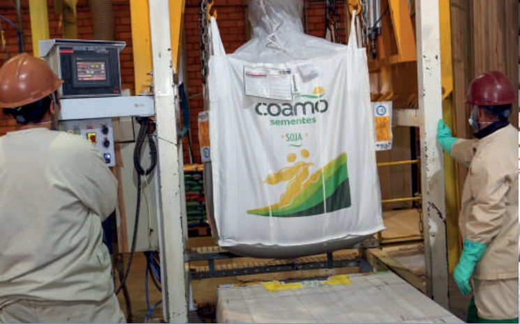 Funcion&aacute;rio ensacando sementes Coamo