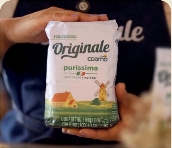 M&atilde;o segurando um pacote da Farinha Originale Pur&iacute;ssima Coamo.