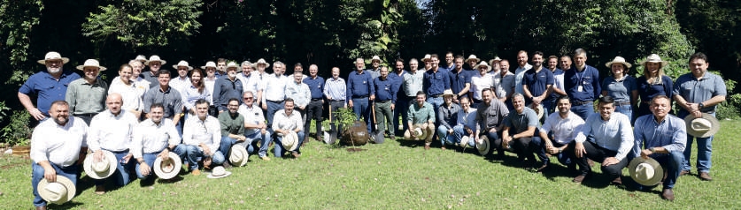 Grupo de pessoas posando para foto durante o plantio de &aacute;rvore em homenagem