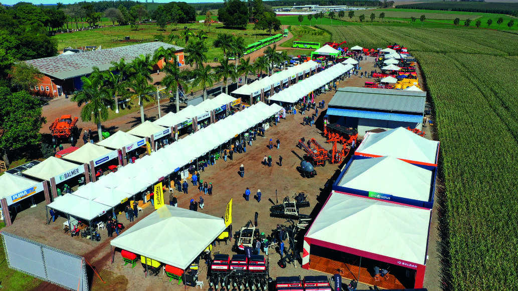 Vista a&eacute;rea da Feira de Neg&oacute;cios, com estandes e m&aacute;quinas agr&iacute;colas expostos.