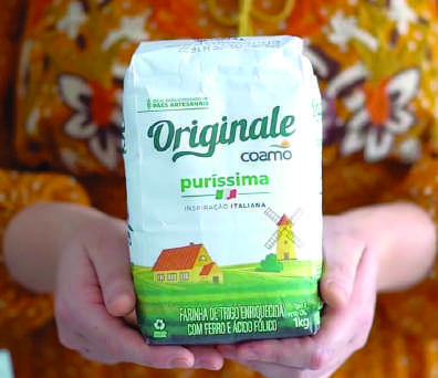 Farinha de Trigo Originale Coamo sendo segurada.