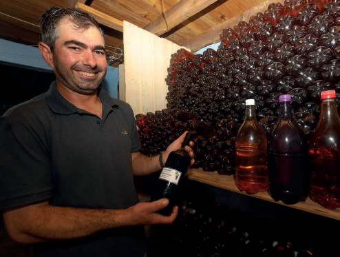 Andr&eacute; Dalmarco com os vinhos produzidos pela fam&iacute;lia