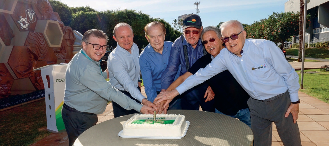 Diretoria e fundadores cortando o bolo comemorativo dos 55 anos da Coamo