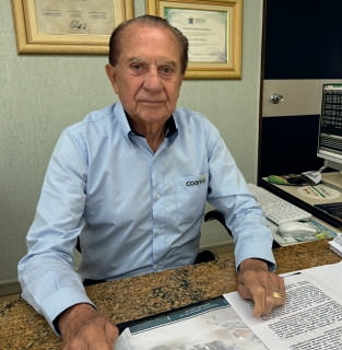 Jos&eacute; Aroldo Gallassini sentado em sua mesa de escrit&oacute;rio