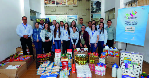 Grupo de funcion&aacute;rios da Coamo com alimentos arrecadados para doa&ccedil;&atilde;o.