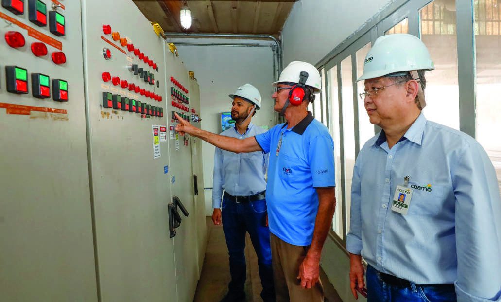 Da esquerda para a direita: Edenilson Carlos de Oliveira, diretor de Log&iacute;stica e Opera&ccedil;&otilde;es, um funcion&aacute;rio da cooperativa e Valter Massashi Yamao, coordenador de Manuten&ccedil;&atilde;o El&eacute;trica, analisam um painel de controle.